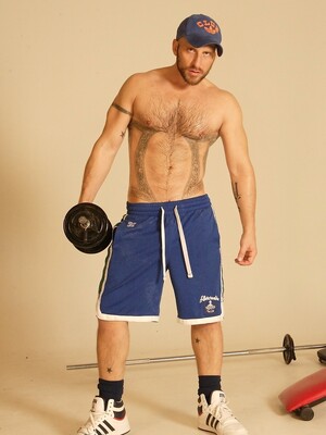 Strong hairy gay athlete Aitor Crash strips naked while lifting weights