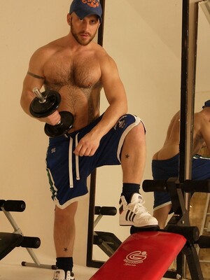 Strong hairy gay athlete Aitor Crash strips naked while lifting weights