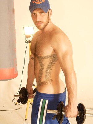 Strong hairy gay athlete Aitor Crash strips naked while lifting weights